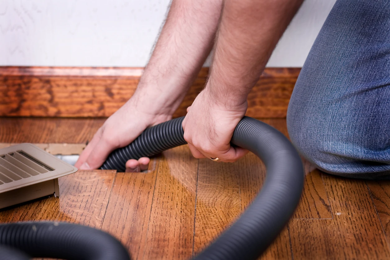 A man is engaged in vacuuming the floor