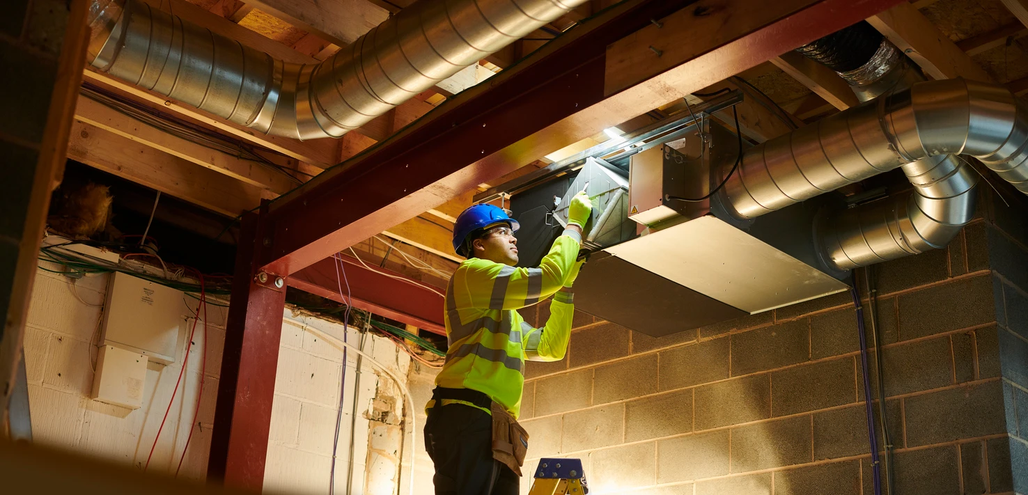 A man is performing maintenance on a ceiling